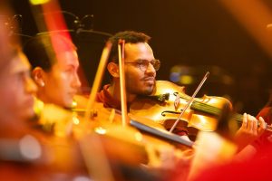 Un joven músico toca el violín concentrado durante la presentación de la Orquesta Batuta Bogotá en el Teatro Mayor.