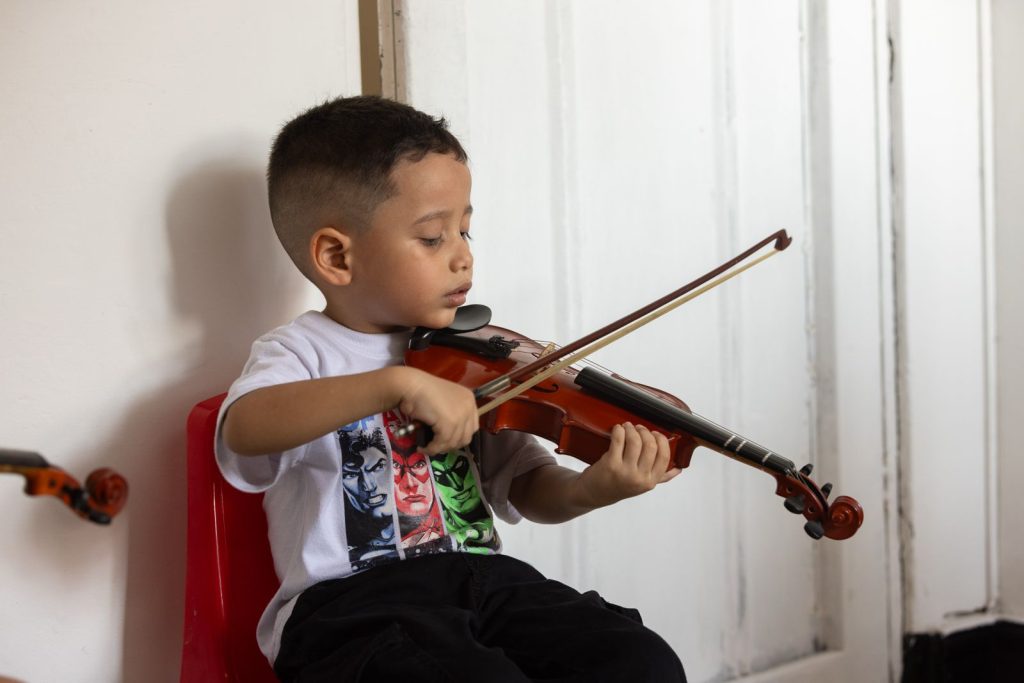 Niño beneficiario del Centro Laboratorio Artístico Nacional tocando el violín
