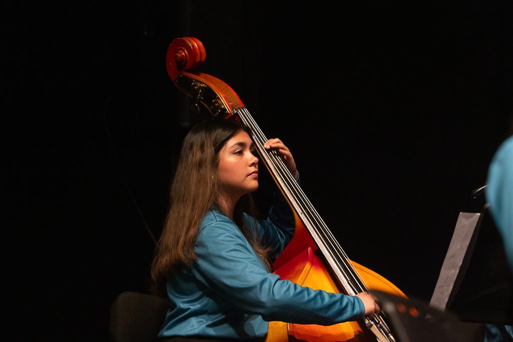Joven tocando el violonchelo durante concierto