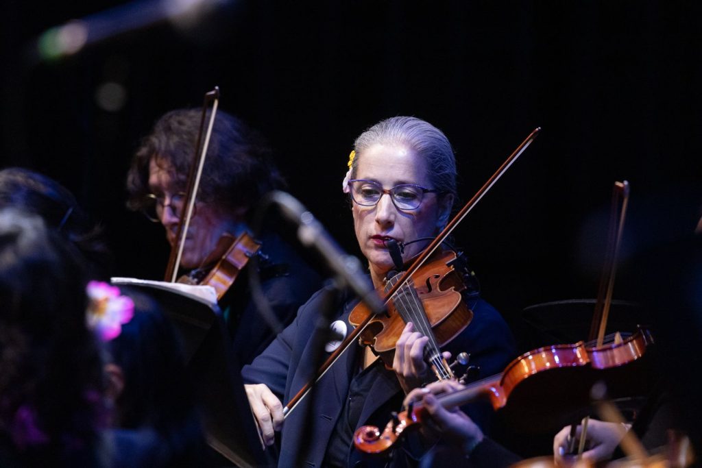 Mujer de radio televisión española con flor en el cabello toca el violín