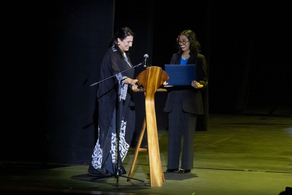 Ministra de Culturas durante el concierto de 35 años de Batuta entregando un premio a estudiante