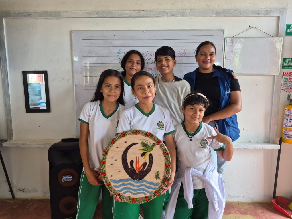 Niños y niñas del Centro Musical DERU en un salón de clases junto con una de sus profesoras de Batuta