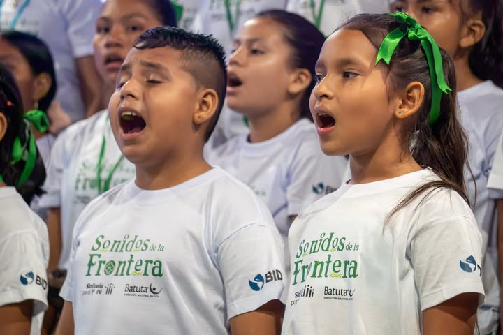 Una niña y un niño cantando juntos durante residencia artística de Sonidos de la frontera