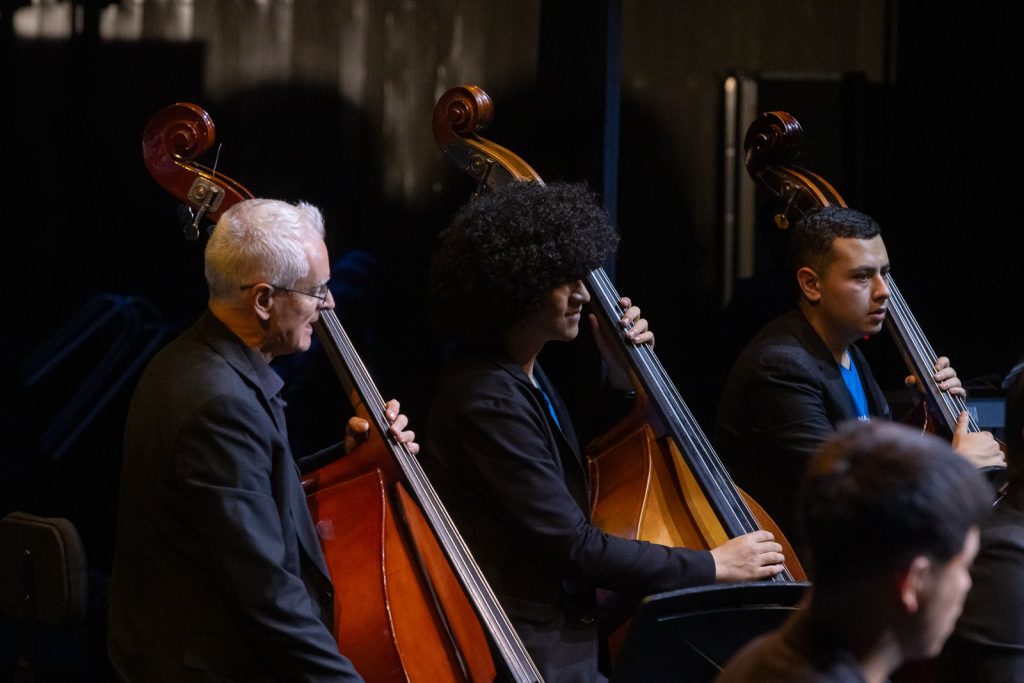 Tres músicos de Colombia y España durante concierto tocando el contrabajo